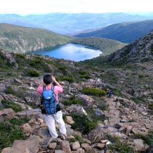 Our guest photographs a hidden lake from high in the Hartz Mountains on the Tasmania National Parks Tour